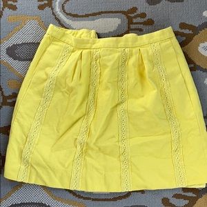 Yellow mini skirt with lace detail and pockets